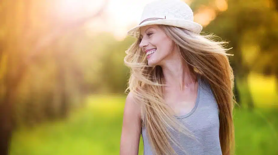 Attractive young woman enjoying her time outside in park with sunset in background.