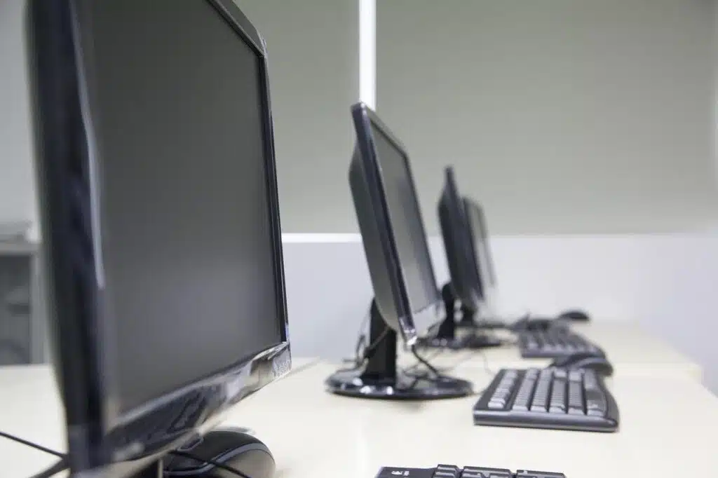 Several computers on a desk.