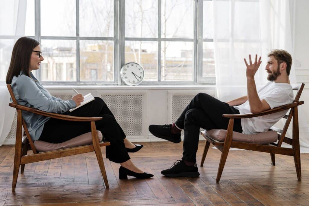 A person and person sitting in chairs AI-generated content may be incorrect.