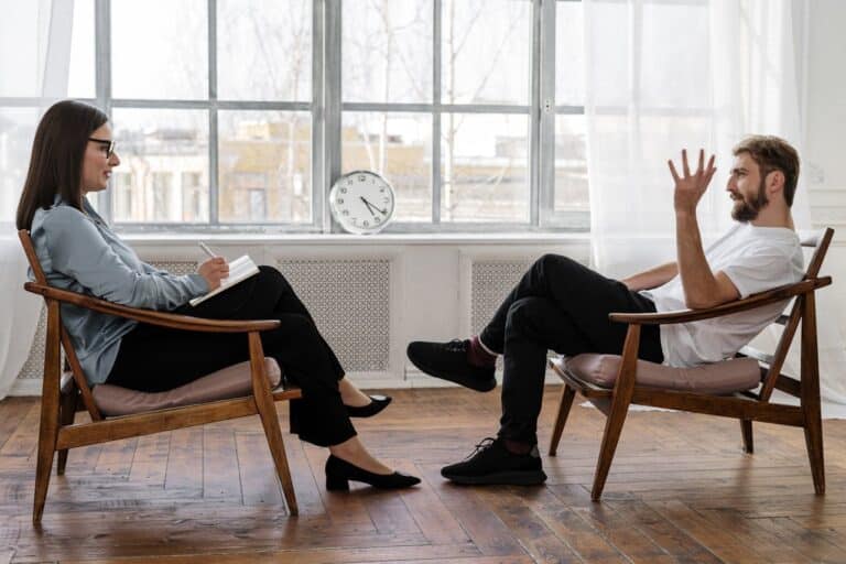 A person and person sitting in chairs AI-generated content may be incorrect.
