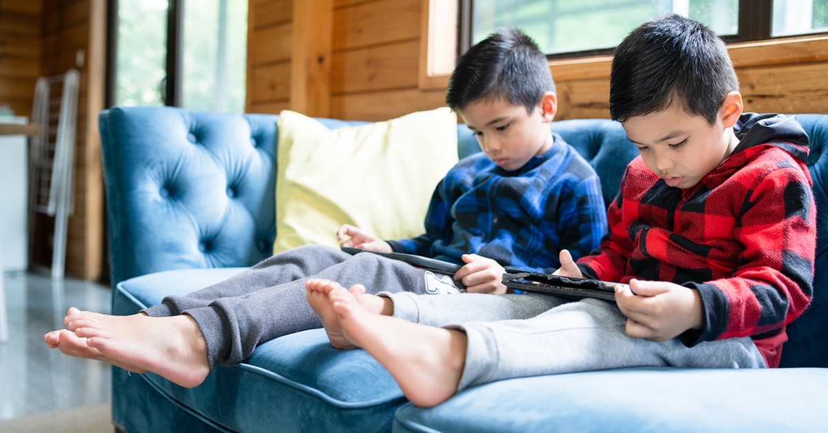 Two boys sitting on a couch AI-generated content may be incorrect.