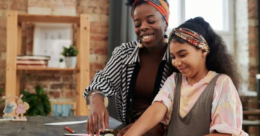 Mother and daughter joyfully crafting together at home, fostering creativity and bonding.