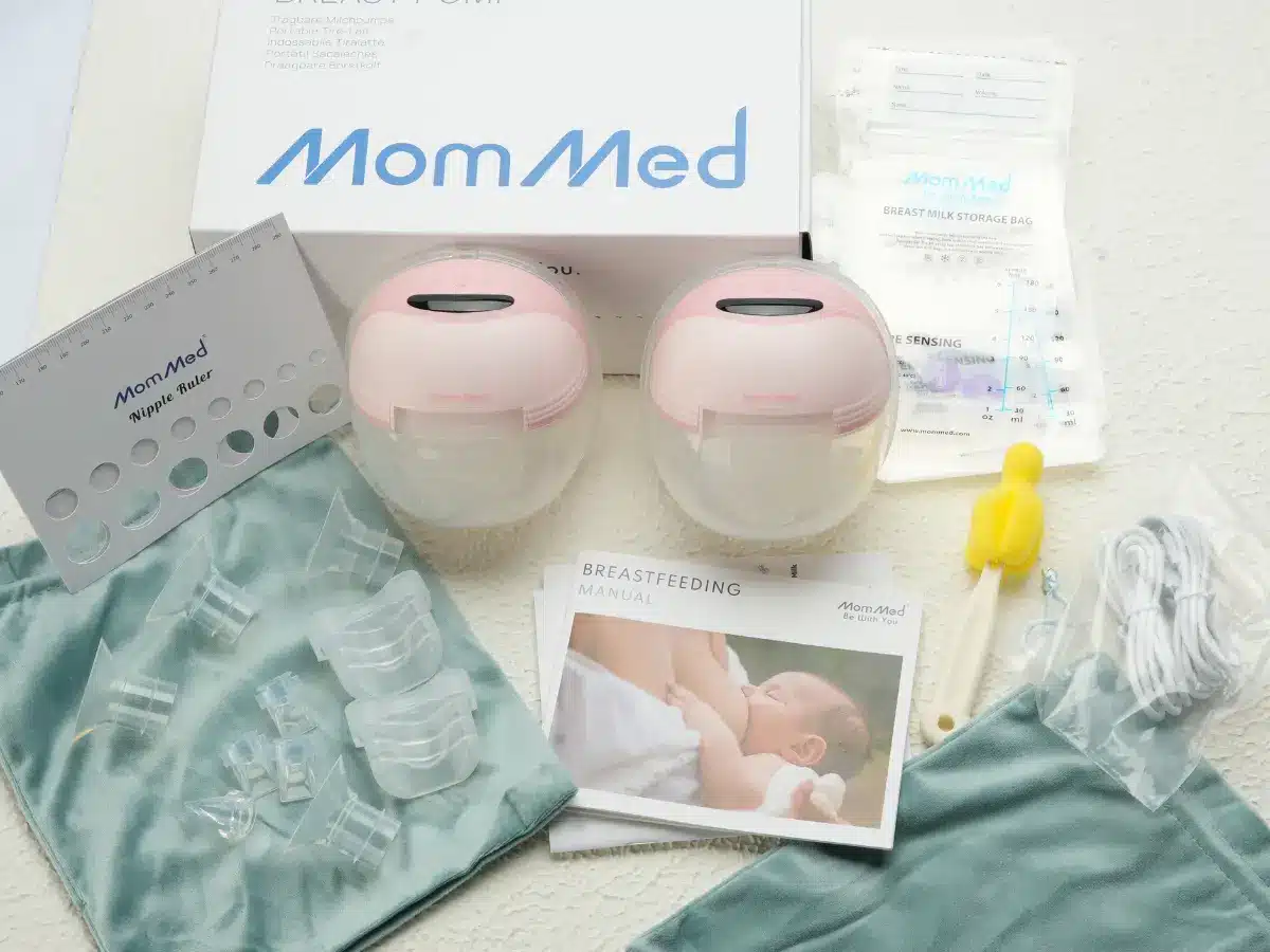 Breast pump equipment with accessories and breastfeeding manual on a textured surface