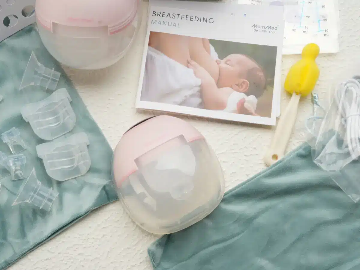 Breast pump kit with manual and accessories on textured surface