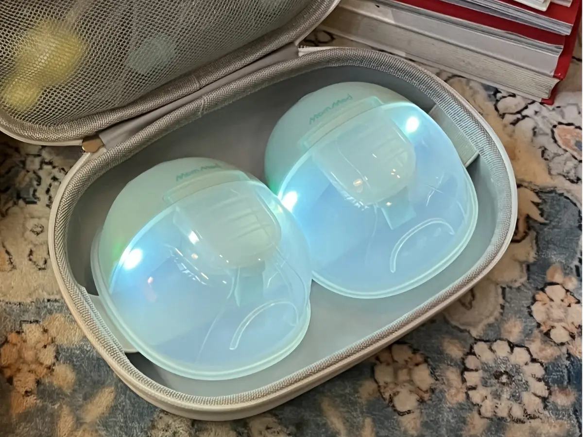 Breast milk pumps with glowing lights in gray carrying case on patterned rug