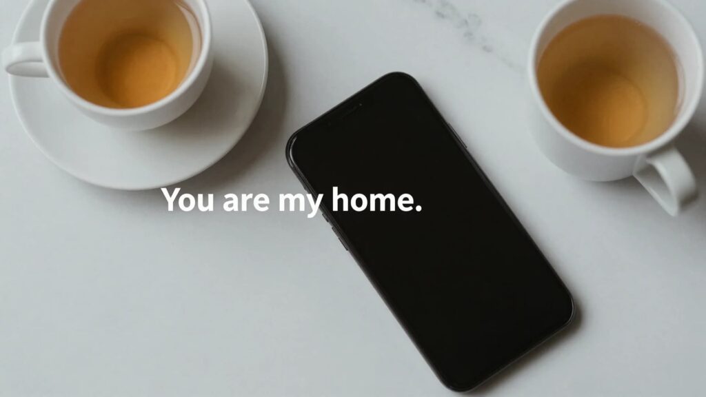 A cozy scene with two cups of tea and a smartphone, with a message that reads “You are my home.”