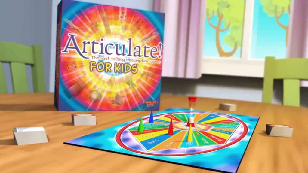 Articulate for Kids board game set up on a table, featuring a colorful circular game board with category sections, player pieces, a timer, and the game box displayed in the background