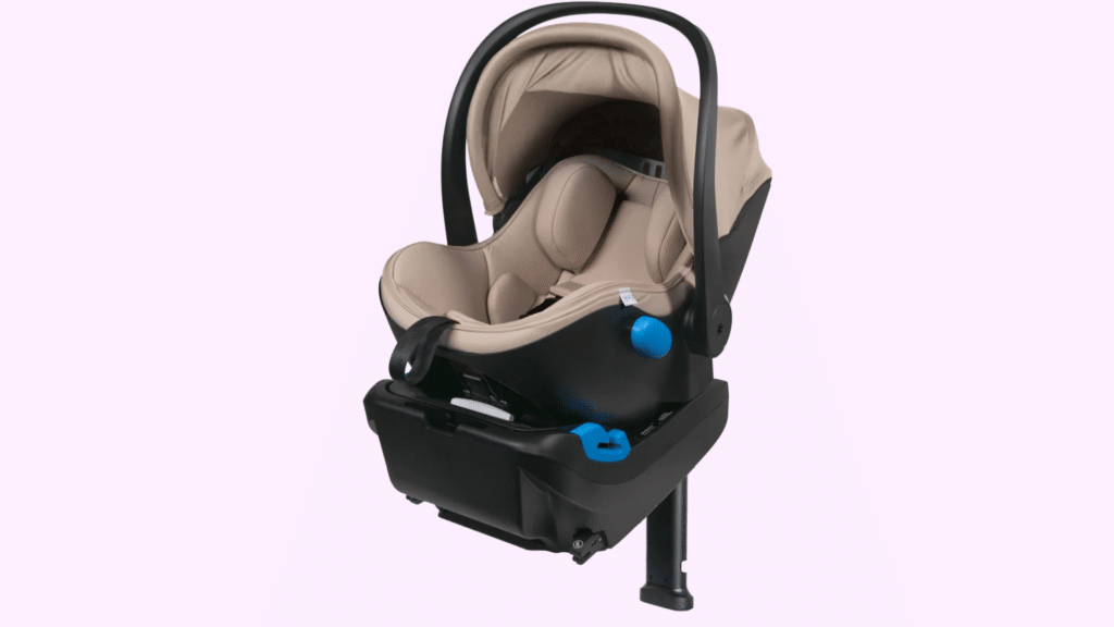 Beige infant car seat with a canopy and handle, mounted on a black base with support leg, isolated on a plain background