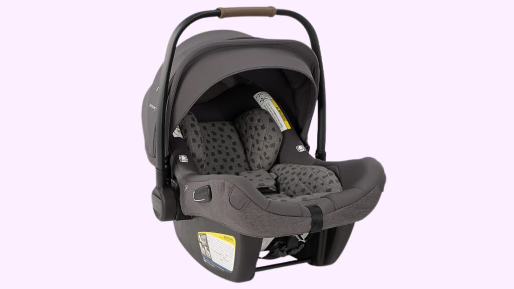 Nuna PIPA Lite RX infant car seat in dark gray with canopy and carry handle, featuring patterned padding and a secure harness system, shown against a plain background