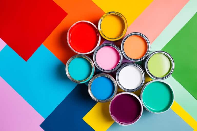 Pot of paints of various colors on multi color canvas