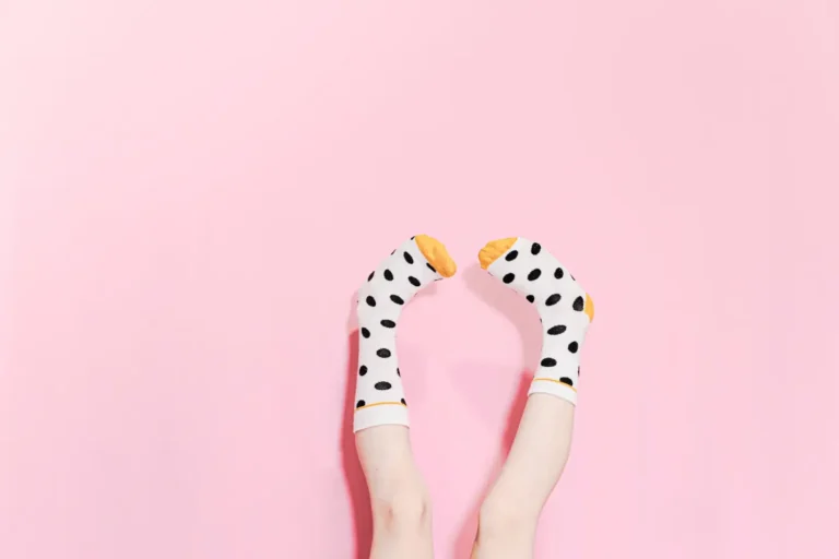 Polka dot socks on feet against a pink background
